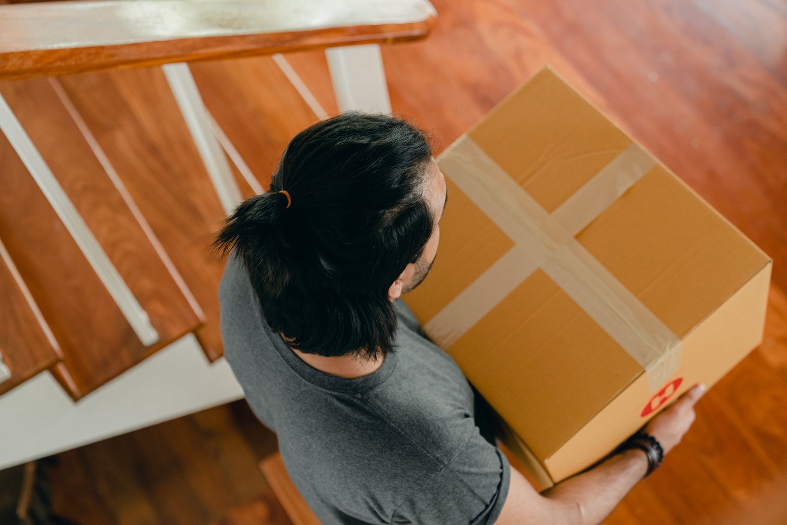 Removalist carrying a labelled carton up the front steps of a Melbourne home